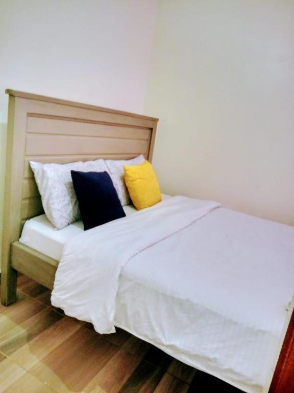 ThikaCozy One bedroom B&B的卧室配有白色的床和色彩缤纷的枕头