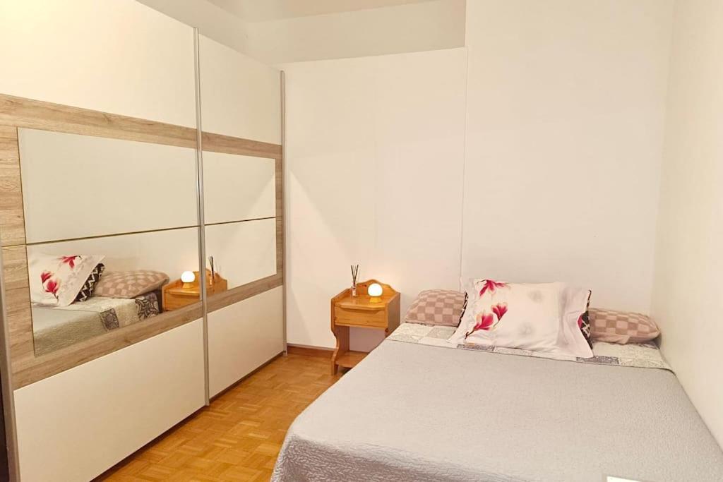 日内瓦Espacioso apartamento的一间小卧室,配有一张床和镜子