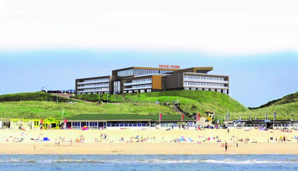 滨海韦克霍格杜茵酒店的海滩上与海滩上的人一起入住的酒店