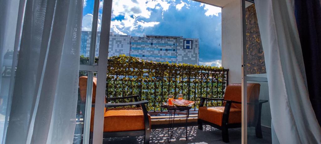 内罗毕Serene Hills Home的阳台配有椅子,享有建筑的景致。