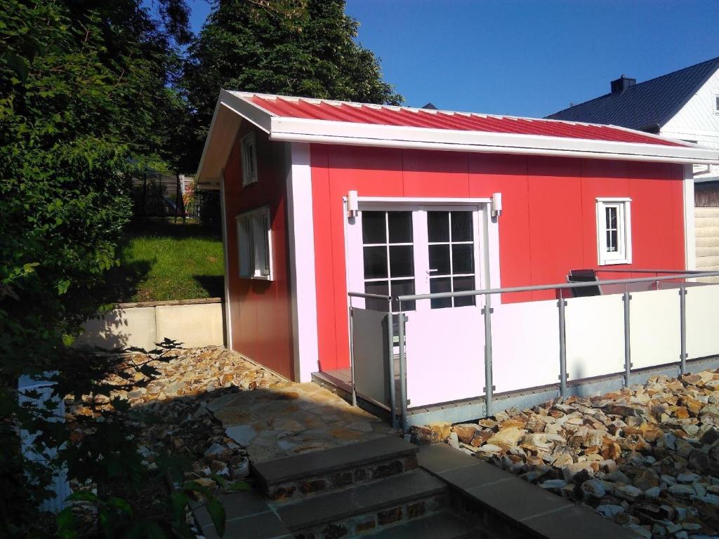 巴特马林贝格Ferienhaus in Bad Marienberg Westerwald mit Grill und Terrasse的一座红色和白色的小建筑,有门