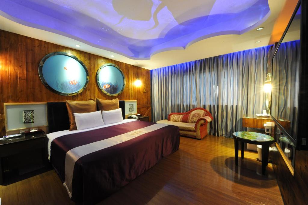 新竹新竹-紫晶彩绘汽车旅馆的酒店客房设有一张大床和一张沙发。