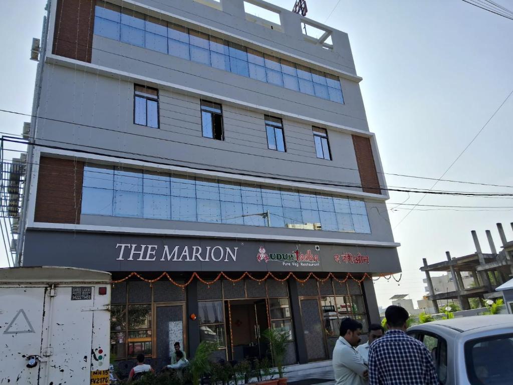 纳西克Hotel The Marion的一座建筑,前面有人