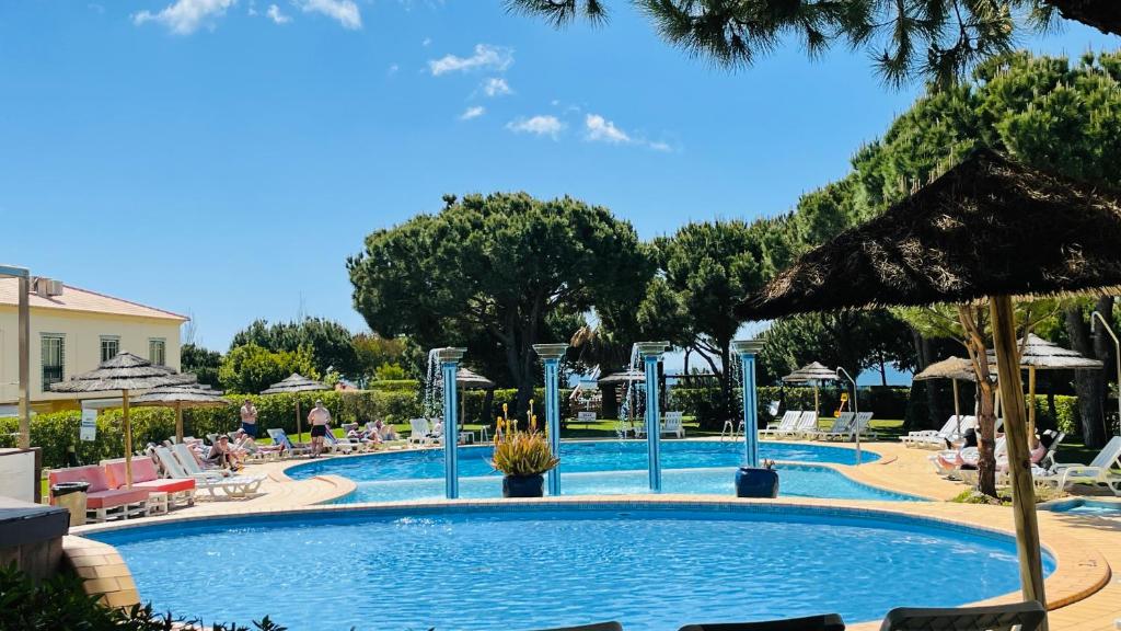 阿尔布费拉Bicos 303 by Check-in Portugal的度假村的游泳池,配有椅子和遮阳伞