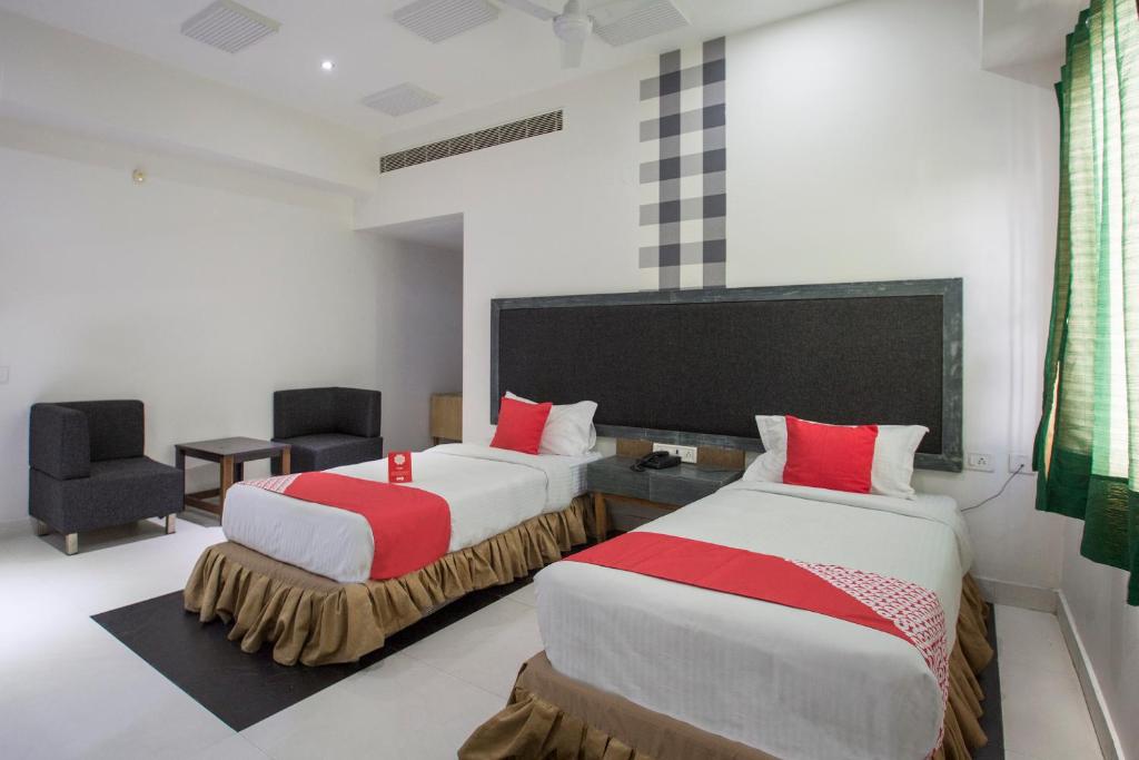 AmeerpetOYO Hotel Palak Residency Near Erragadda Metro Station的酒店客房,配有两张床和椅子