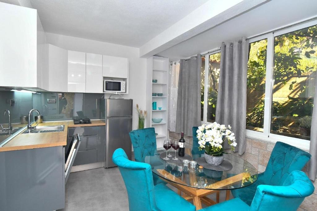 格拉达茨Nettes Appartement in Gradac mit Terrasse的厨房配有玻璃桌和蓝色椅子