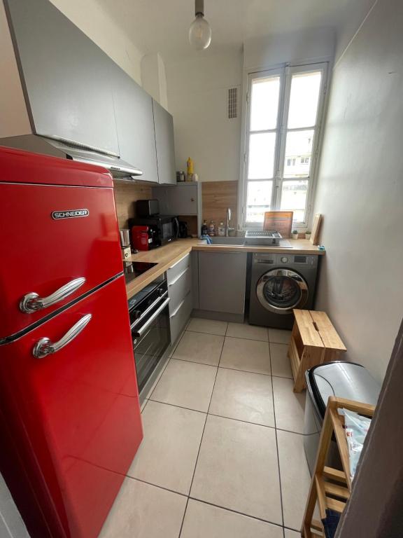 库尔布瓦Profitez du calme de Courbevoie La Défense的厨房配有红色冰箱和洗衣机