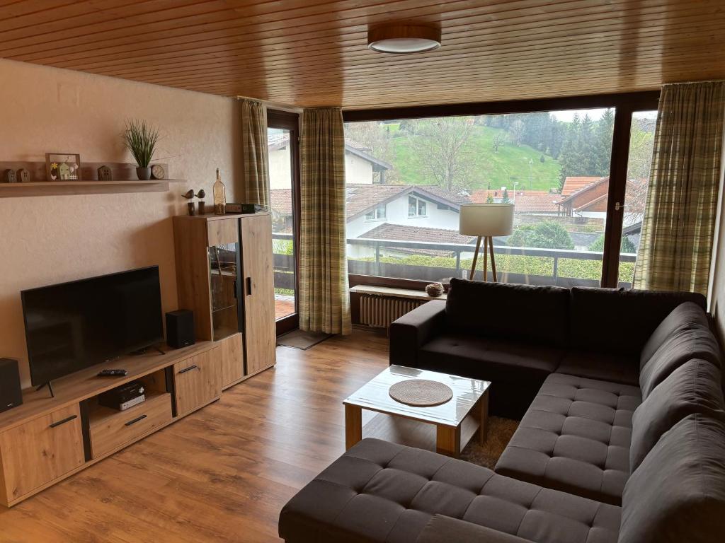 上施陶芬Schöne 2 1/2 Zimmer Ferienwohnung in Oberstaufen - Hoamatle -的带沙发和大窗户的客厅