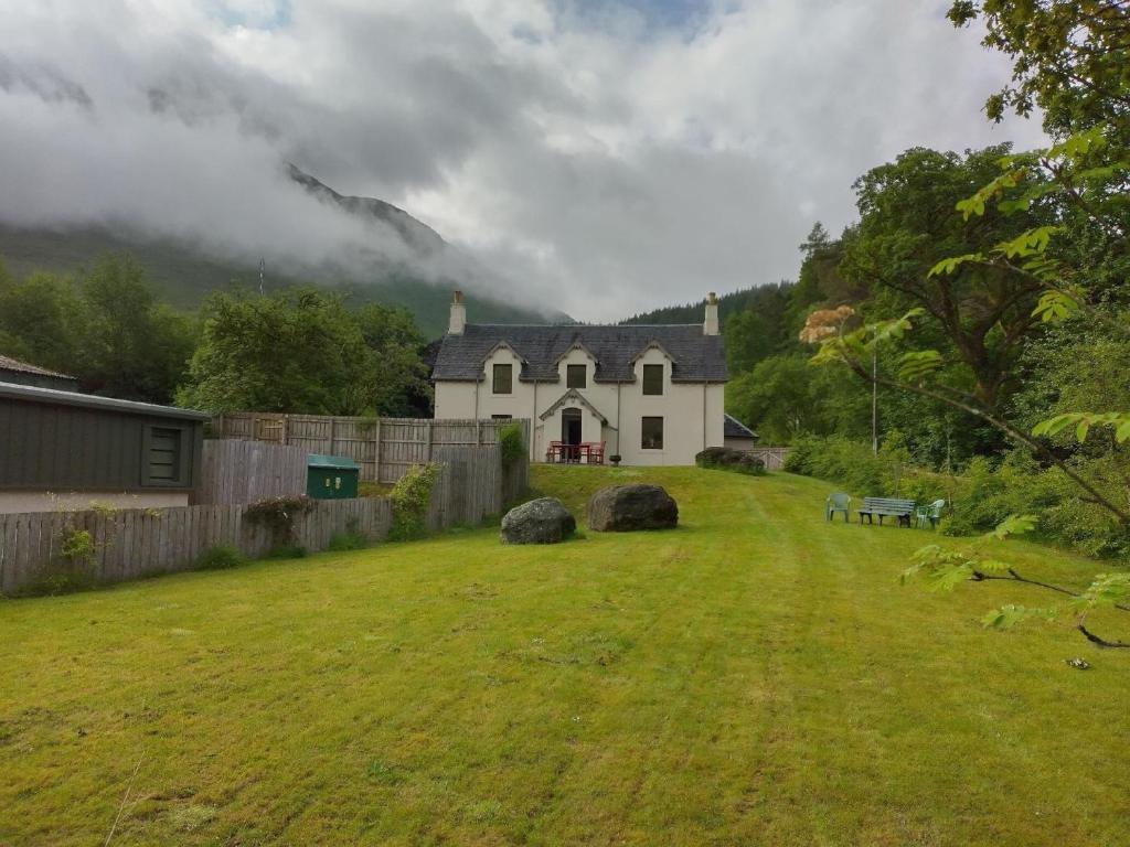 克里安拉利Ferienhaus für 6 Personen ca 100 qm in Crianlarich, Schottland Loch Lomond and the Trossachs Nationalpark的房子前面有草地的房屋