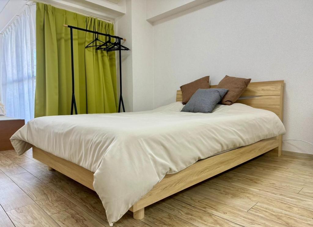 名古屋Rainbow takakura - Vacation STAY 16466的一间卧室配有一张带绿帘的大床