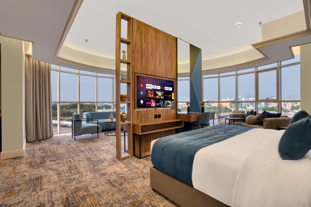 吉达Aluya Hotel的配有一张床和一台平面电视的酒店客房