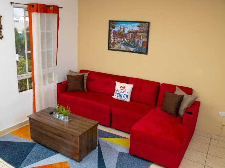 Antiguo CuscatlánCozy Two Bedroom Apartment Near The U.S. Embassy的客厅里一张红色的沙发,配有茶几