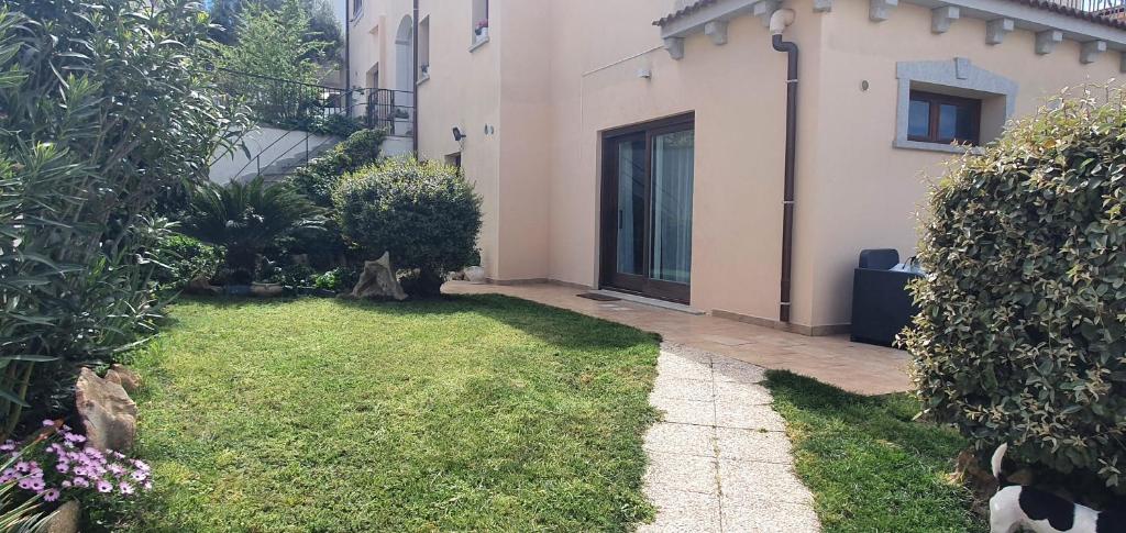 奥尔比亚Eleonora's apartment的一座带房子的花园和一个草地庭院