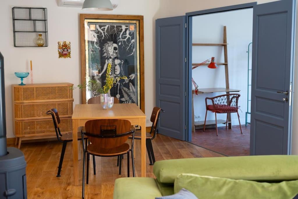 VeroAppartement T3 bas de Villa的客厅设有蓝色的门和桌子