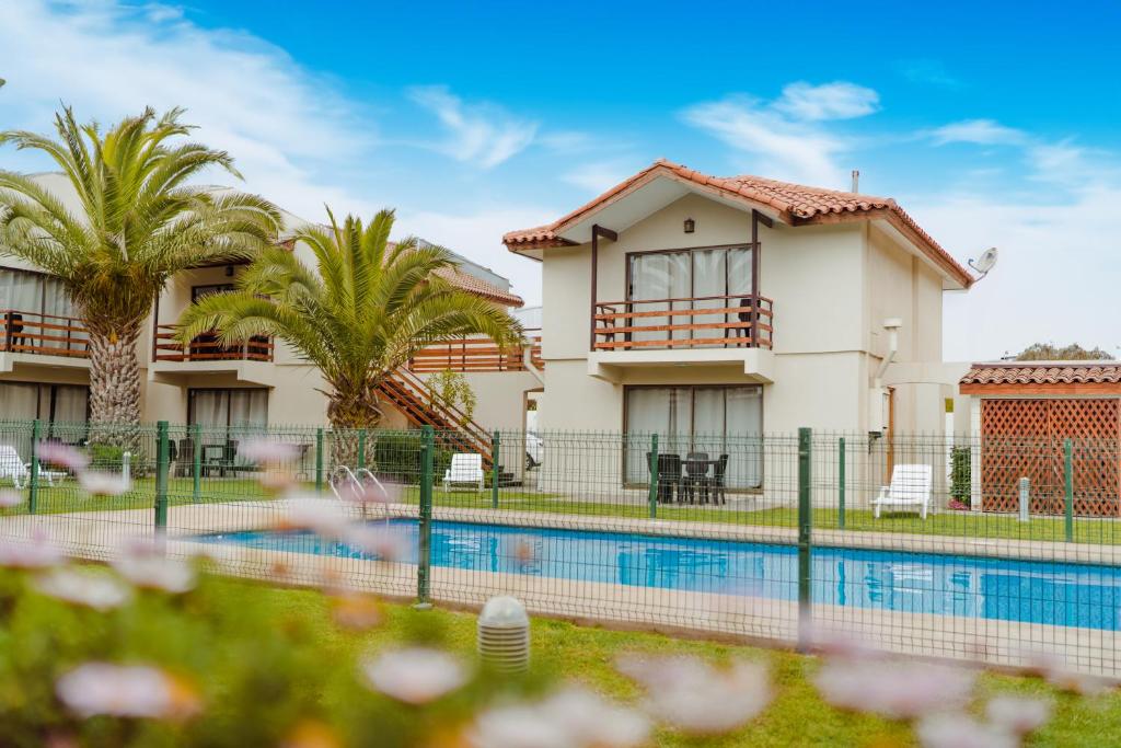 拉塞雷纳Agua Marina - La Serena的一座带游泳池和棕榈树的房子
