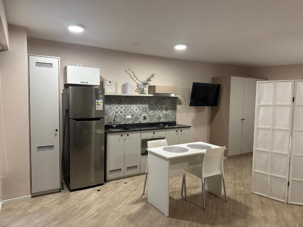 利马Friendly Apartment Tamayo的厨房配有不锈钢冰箱和桌子