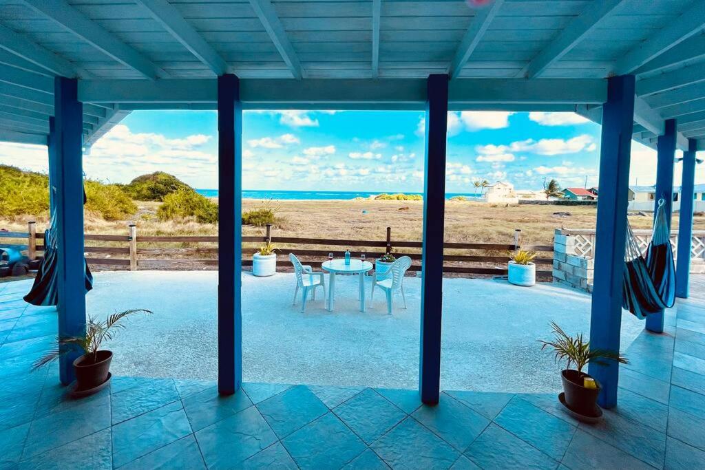 圣菲利普Serenity by the Sea: Ocean Front Villa with Pool的海滩上带桌椅的天井