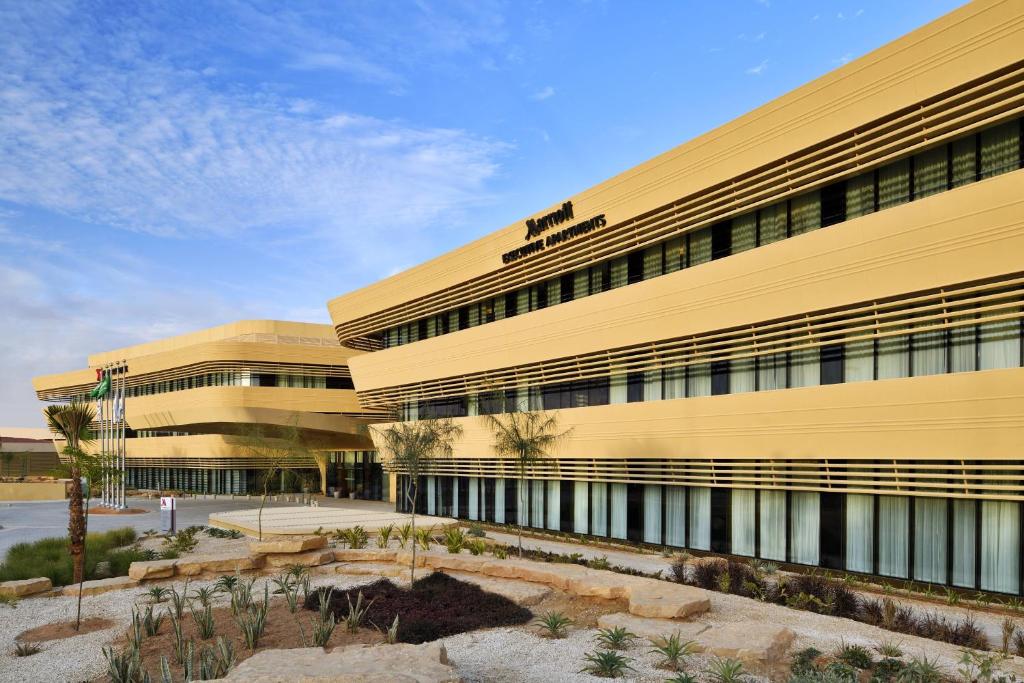 利雅德Riyadh Diplomatic Quarter - Marriott Executive Apartments的黄色建筑的办公楼
