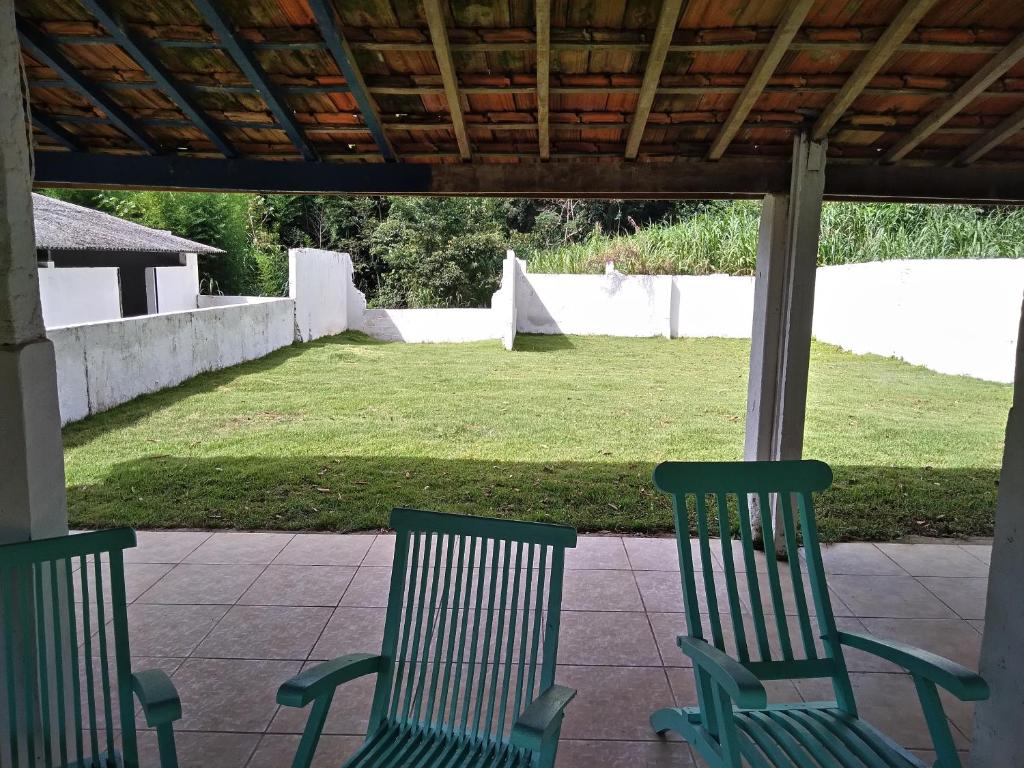 若阿诺波利斯Joanopolis Inn - Mantiqueira 1的两把绿色椅子坐在庭院的庭院里,庭院里设有庭院