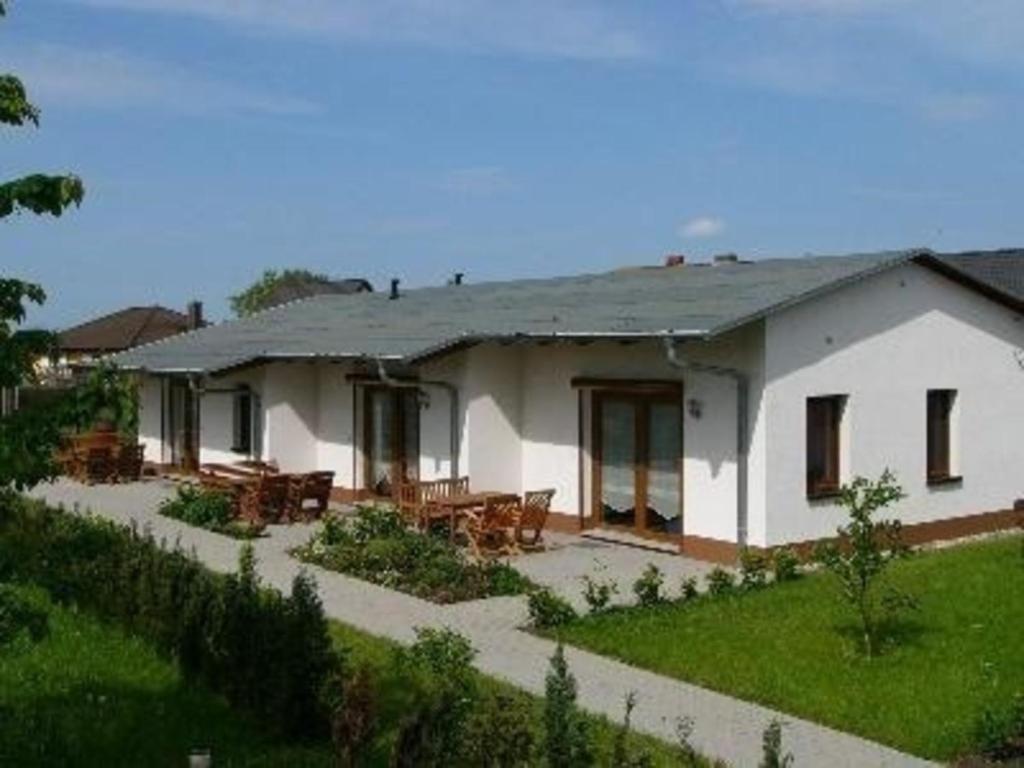 萨勒Ferienwohnung mit zwei Schlafzimmern und Terrasse - b63281的院子内带桌椅的白色房屋