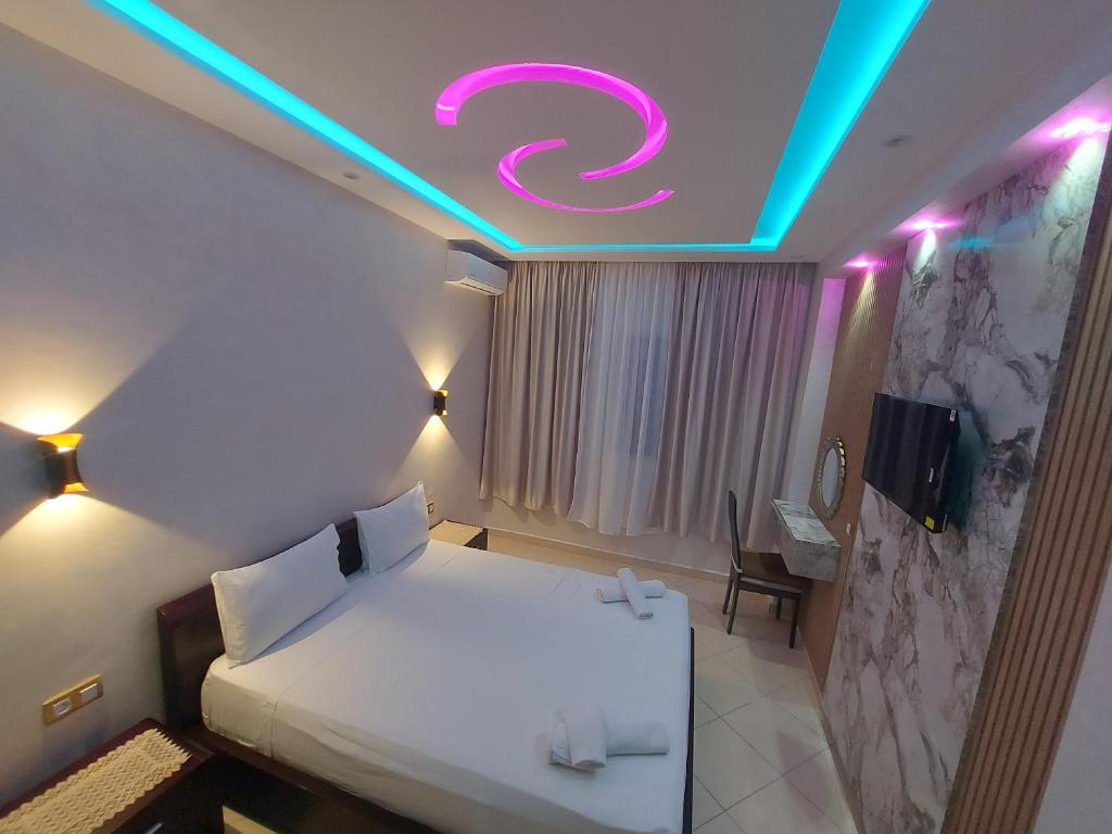 丹吉尔borj rayhane 1的一间卧室,床上的天花板上设有 ⁇ 虹灯标志