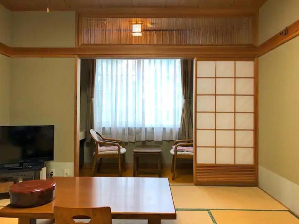 南鱼沼市Koguriyama Sanso - Vacation STAY 43377v的客厅配有桌子和窗户