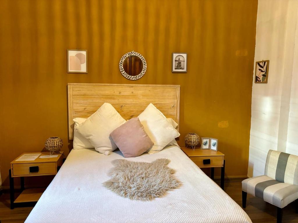蒙得维的亚Terminal expres的卧室配有一张带白色棉被和椅子的床