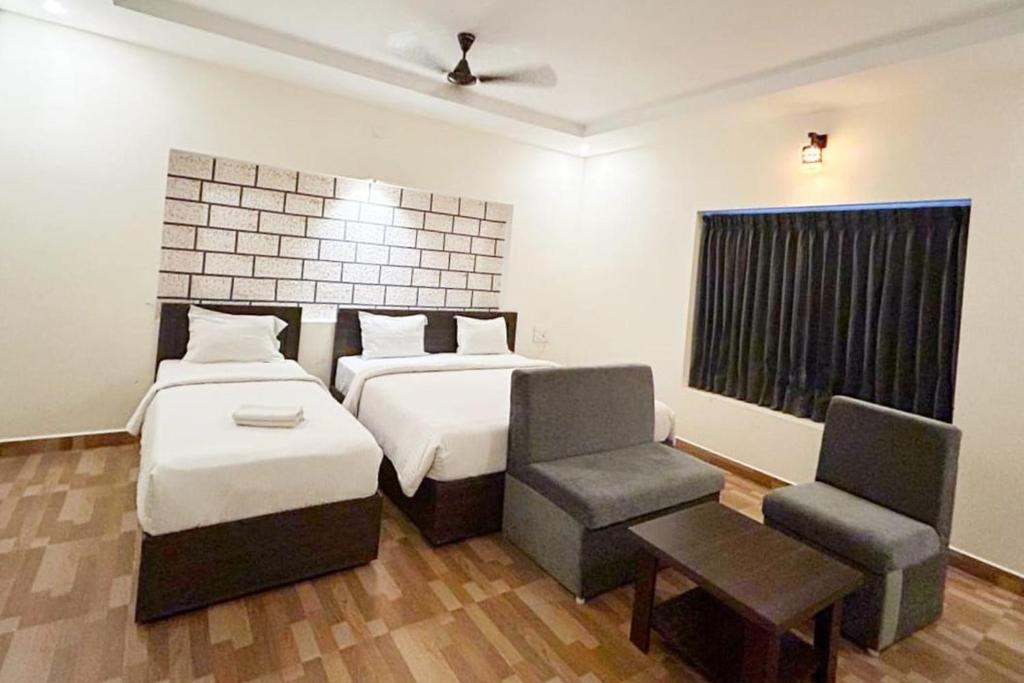 埃尔加德R Hotels By Suraj Residency Yercaud的一间卧室设有两张床、一把椅子和一个窗户。