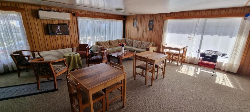 瓦尔迪维亚Hostal Prat II的客厅配有椅子、桌子和沙发