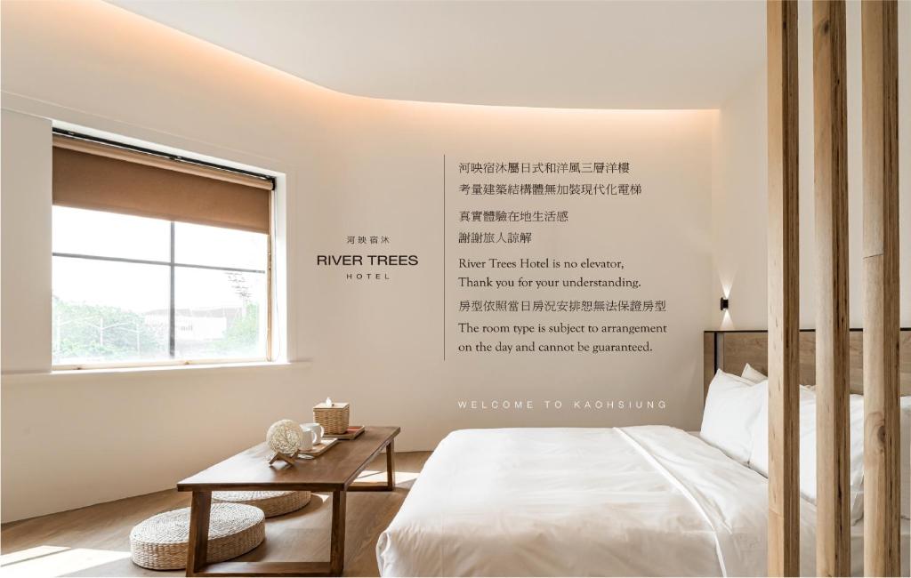高雄河映宿沐 River Trees Hotel的卧室配有一张床,墙上写着一篇文章