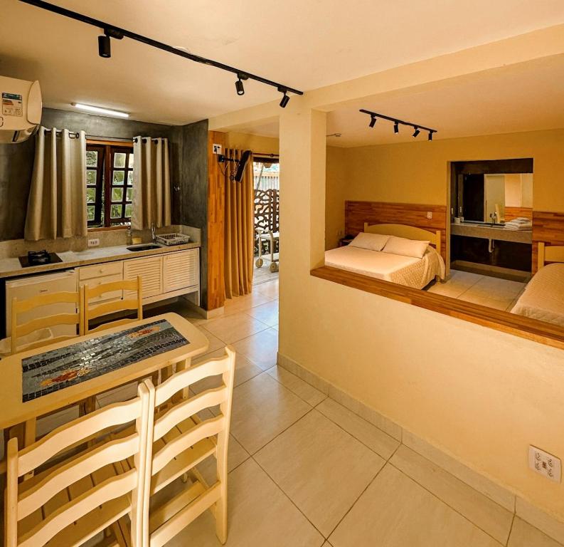 马利西亚斯Villa'l Mare Hotel的一间卧室配有一张床铺和一张桌子,还设有一间厨房