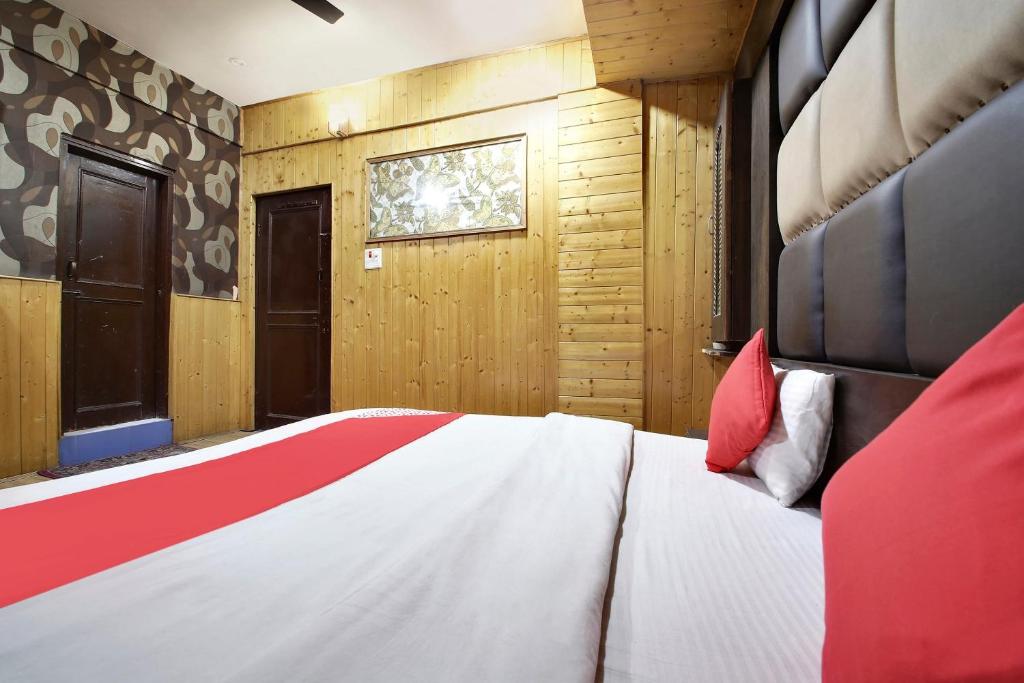 贾姆穆OYO Hotel Azad的一间卧室配有一张带红色枕头的大床