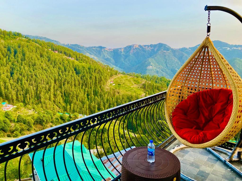 西姆拉Royal Green Valley View Mashobra的山景阳台上的秋千椅