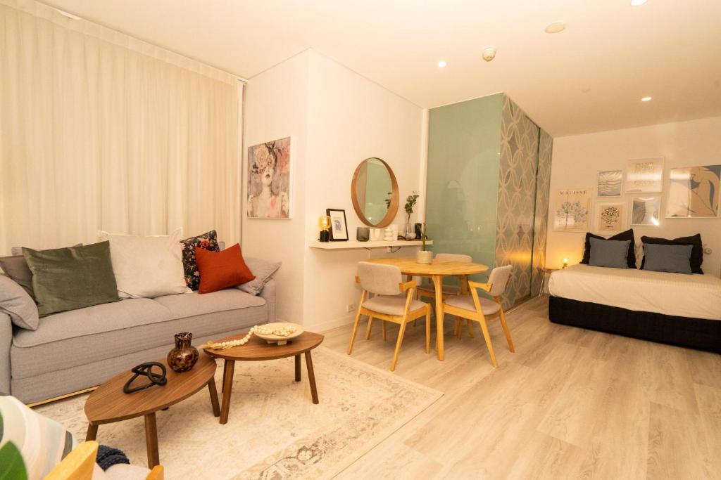 墨尔本Chic Studio Apartment in Melbournes CBD的带沙发、床和桌子的客厅