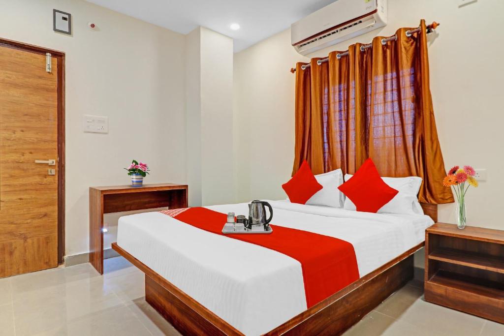 海得拉巴OYO Hotel Night Eye的一间卧室配有一张带红色枕头的大床