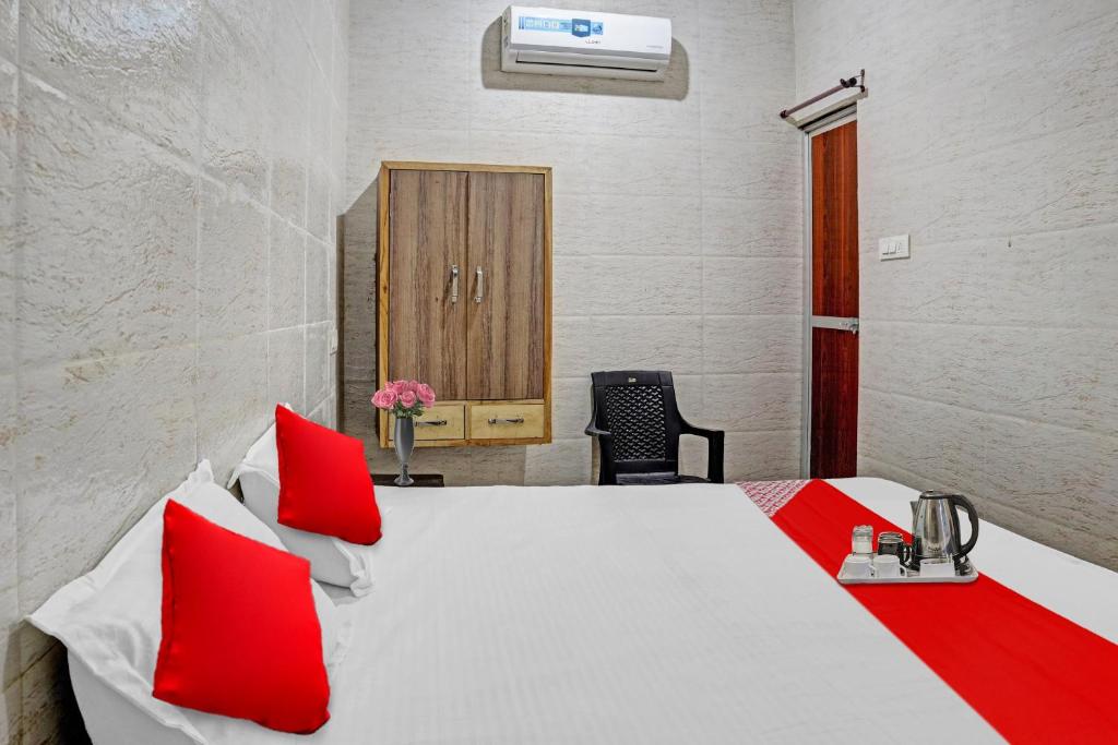 比拉斯布尔Flagship New Mansi Hotel的卧室配有带红色枕头的白色床