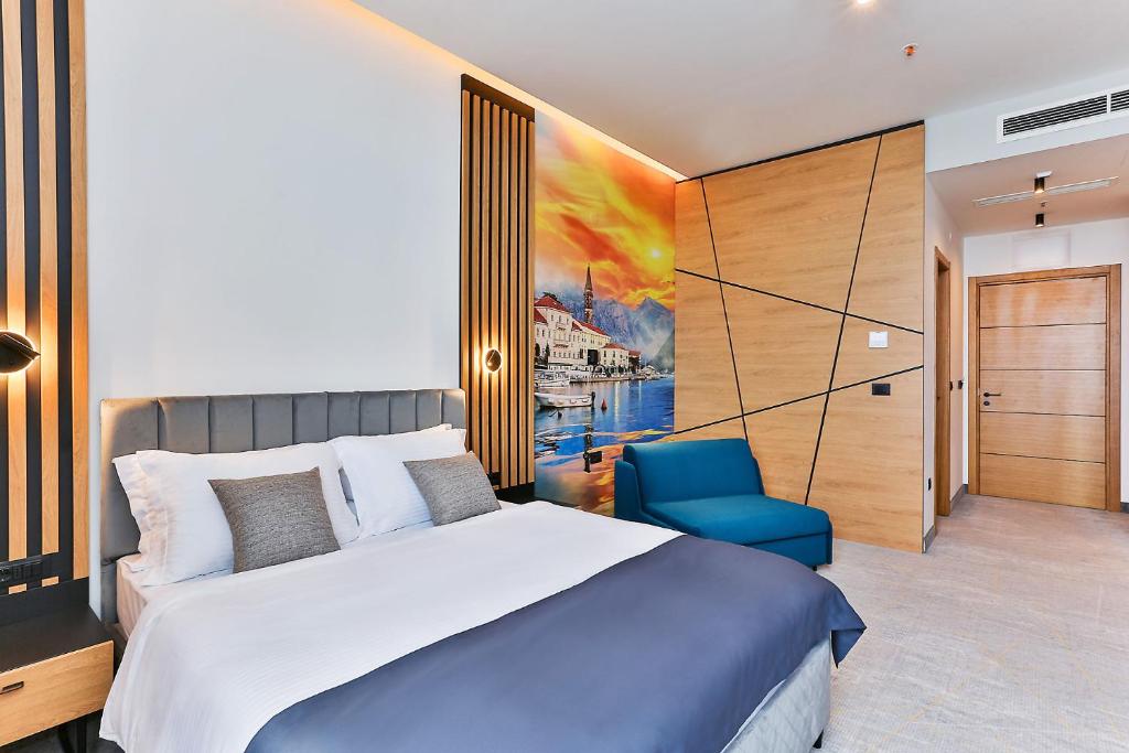 科托尔Hotel Boka的一间卧室配有一张大床和一张蓝色椅子