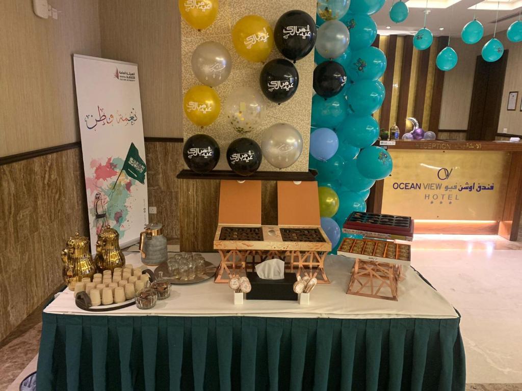 吉达Ocean View Al Zahra的一张桌子上放着蛋糕和气球