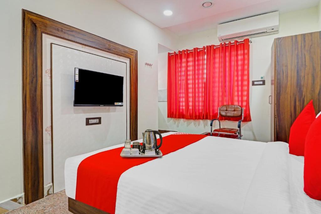 海得拉巴Heavens Inn Near Rasoolpura metro station的卧室配有红色和白色的床和电视。