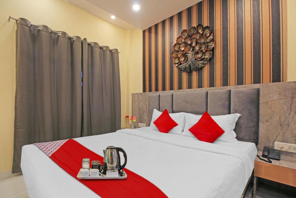 加尔各答Avenue Inn Near Birla Mandir的一间卧室配有一张带红色枕头的大床