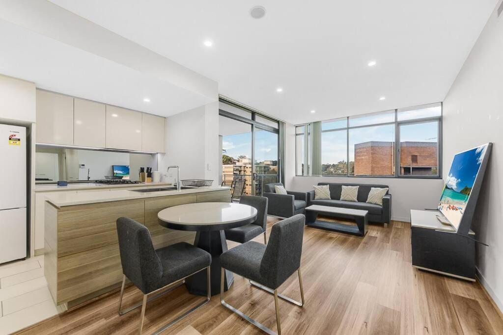 悉尼Two Bedroom Private Apartment In Lane Cove with Parking的厨房以及带桌椅的起居室。
