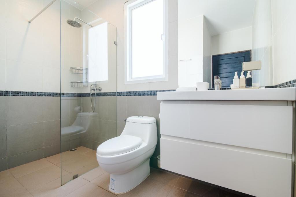 三百岭东方海滩明珠度假酒店的白色的浴室设有卫生间和淋浴。