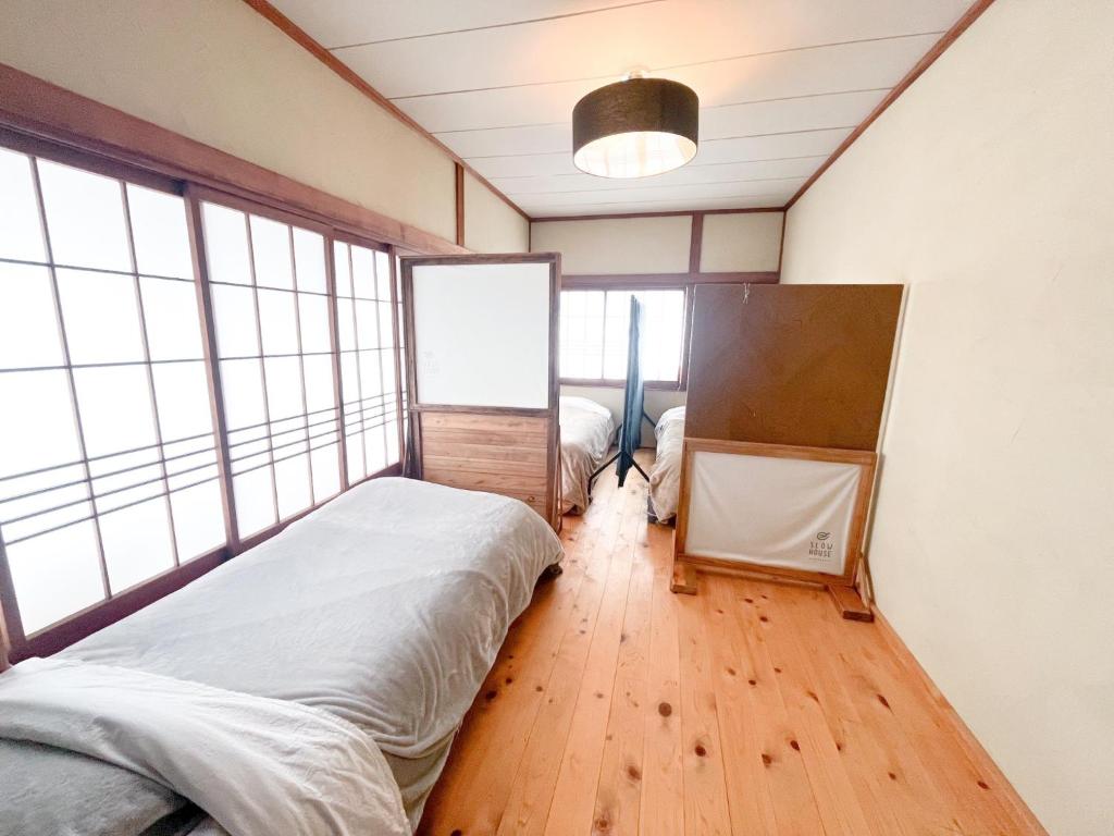 气仙沼市Dormitory SLOW HOUSE Kesennuma- Vacation STAY 30914v的一间设有床铺的卧室,位于带窗户的房间内