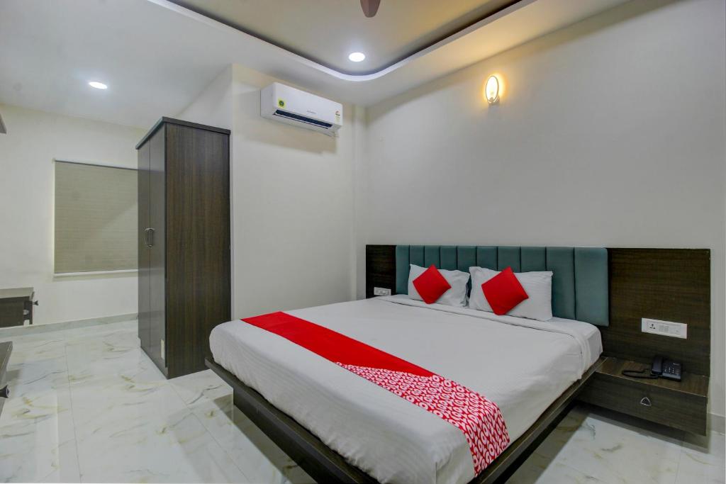 瓦朗加尔BHILVA INN的一间卧室配有一张带红色枕头的大床