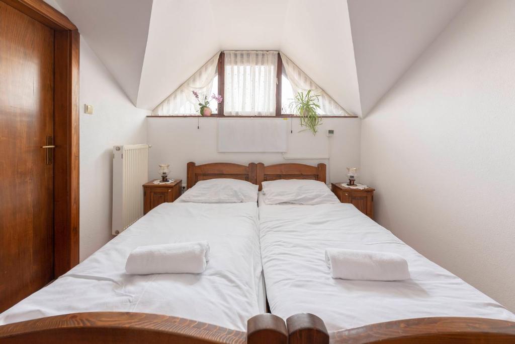 卡姆尼克米利威赫住宿加早餐旅馆的一间卧室配有一张带白色床单的床和一扇窗户。
