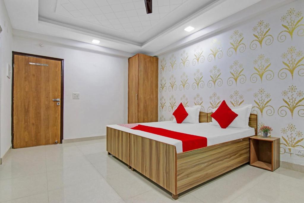 新德里Flagship Hotel Check Inn的一间卧室配有红色枕头的床