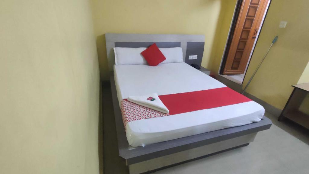 NagriOYO 83046 Hotel Darpan的一间卧室配有一张带红白毯子的床