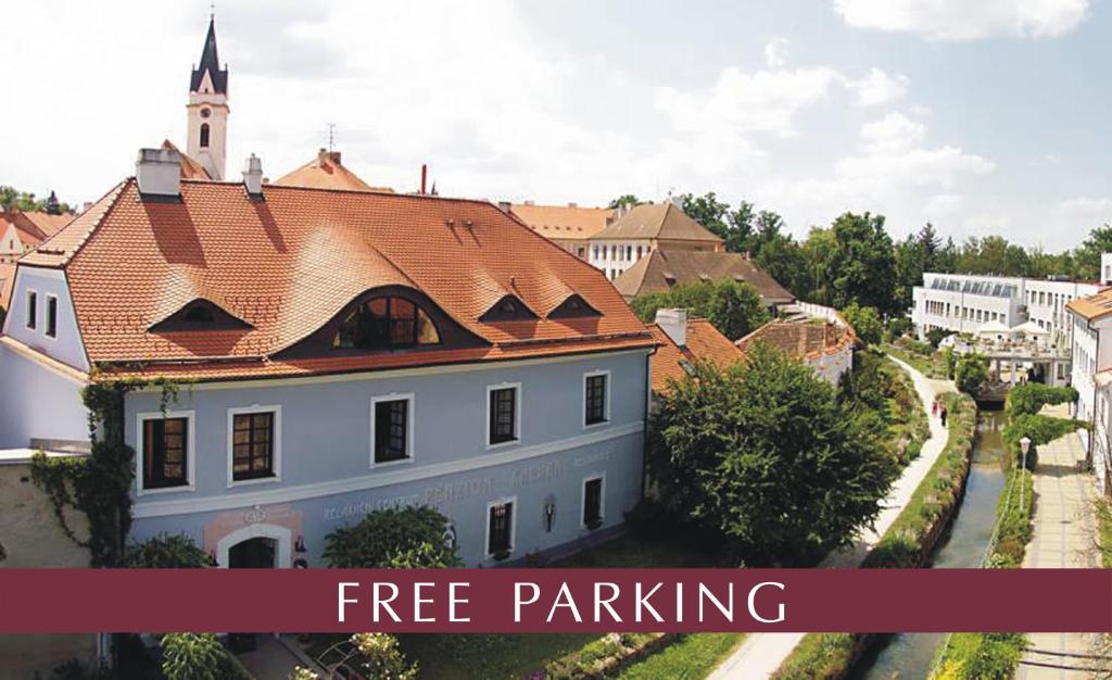 特热邦Penzion a restaurace U Míšků的白色的建筑,有红色的屋顶,有文字免费停车位