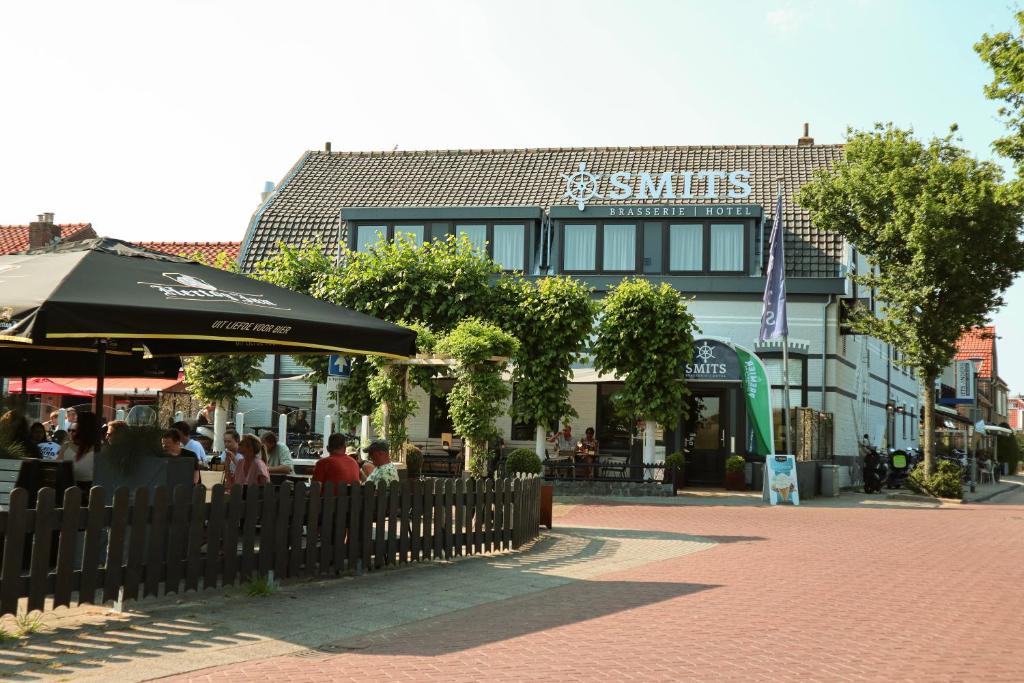 韦默尔丁厄Hotel Brasserie Smits的一间餐厅,有坐在大楼前的人