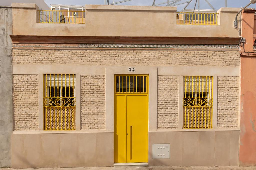 塞维利亚Lemon House Share and Enjoy的砖楼一侧的黄色门